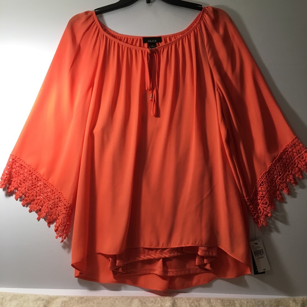 New. Soft orange top with flared sleeves.